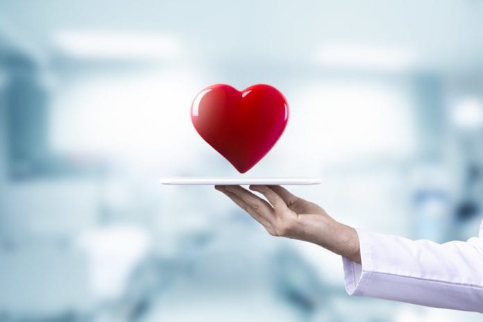 physician holding tablet with heart above