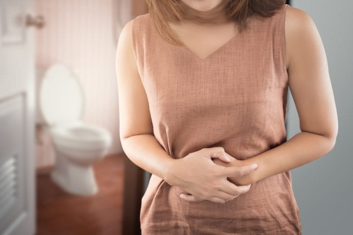 woman with stomach ache outside of restroom