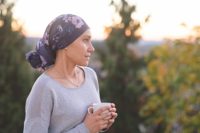 woman with cancer outdoors stares contemplating