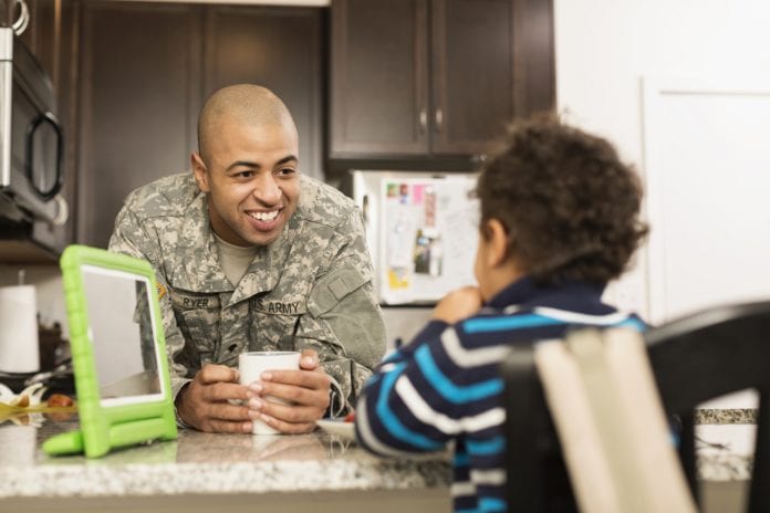 veteran with son at kitchen with digital tablet