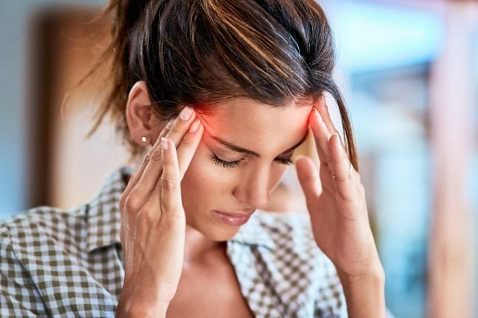 woman holding head with migraine