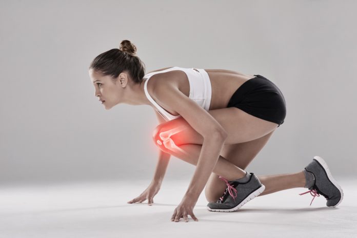 young woman athlete with knee pain highlighted