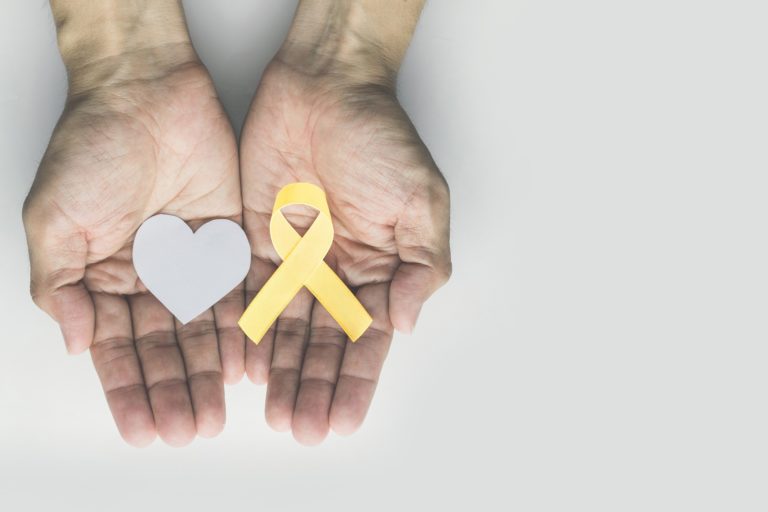 hands holding heart shape and cancer ribbon
