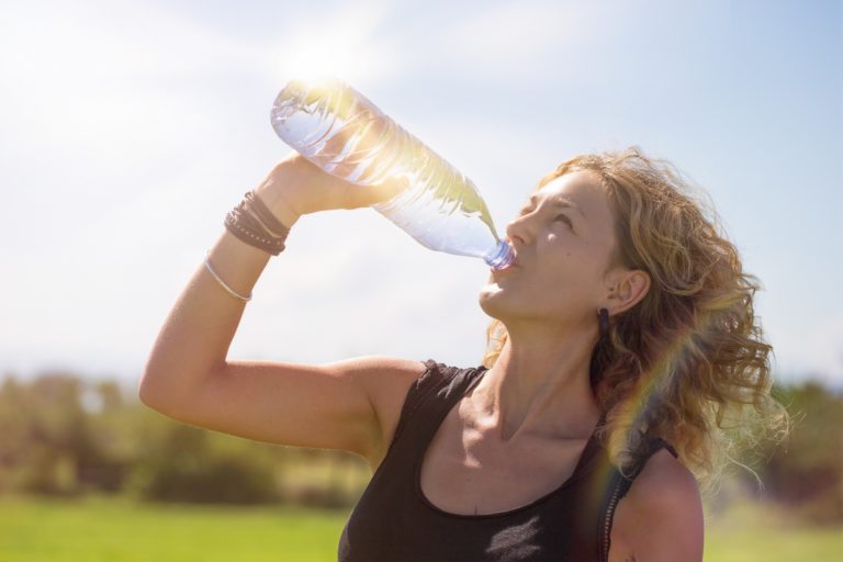 woman drinking water on sunny day