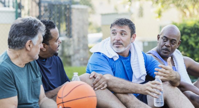 group of men resting and hydrating at basketball court