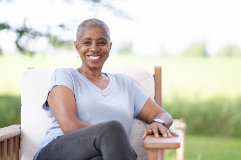 middle aged woman cancer survivor smiling and sitting outside