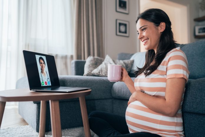 pregnant woman at home on telemedicine call with her physician