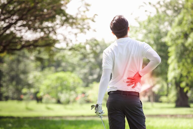 golf player holds injured lower back