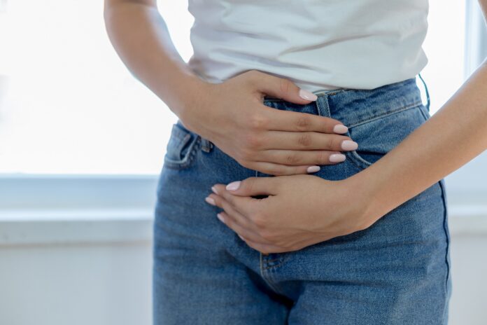 woman holds lower stomach