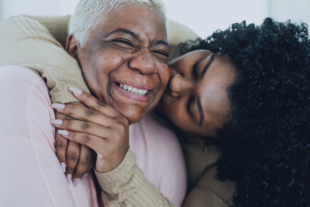 person with dementia and her caregiver embrace